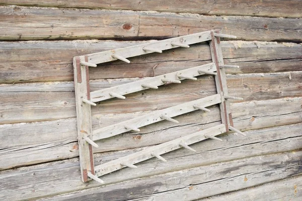 一个古老的木耙挂在木房子的墙上 — 图库照片