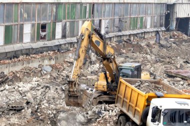 Modern kazıcı depremden sonra bir binanın enkazını temizler.