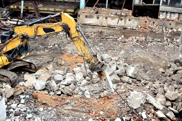 Hidrolik çekiçli modern güçlü kazıcı binayı yıkıyor.