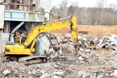 Modern kazıcı depremden sonra bir binanın enkazını temizler.