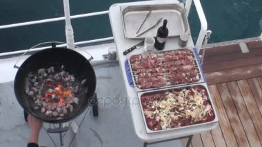 Barbekü İzlanda suya bakan gemide. Barbekü Cook hazırlar.
