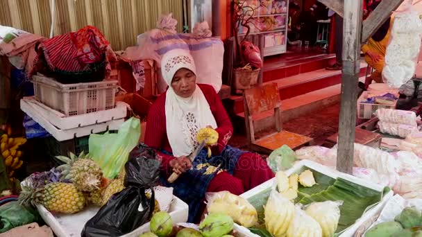 Mujer limpia piña en el mercado de alimentos en Yakarta, Indonesia . — Vídeos de Stock