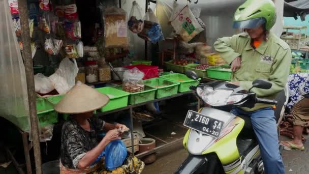 骑自行车的人买了商品在雅加达，印尼的食品市场. — 图库视频影像