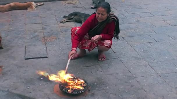 Frau in der Nähe des heiligen Feuers auf den Straßen von Kathmandu in Nepal. — Stockvideo