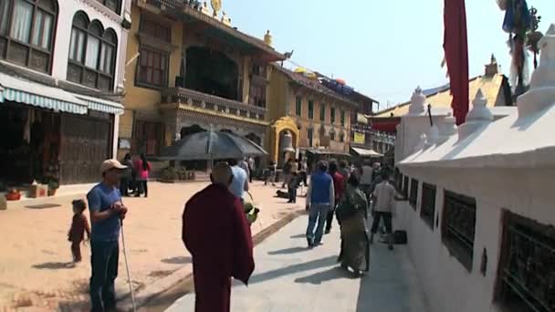 Menschen gehen entlang der Wände eines heiligen Ortes in Kathmandu in Nepal. — Stockvideo