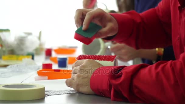 Mano de maestro haciendo patrón de esponja en una taza de cerámica. Diseñador profesional . — Vídeo de stock