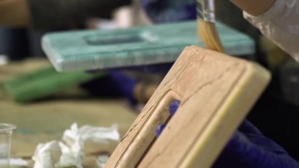 Hände von Künstlern bemalen Rahmen in einer kreativen Werkstatt. — Stockvideo