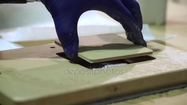 Handen in handschoenen professionele ontwerper wordt een afbeelding ingevoegd in frame in werkplaats. — Stockvideo