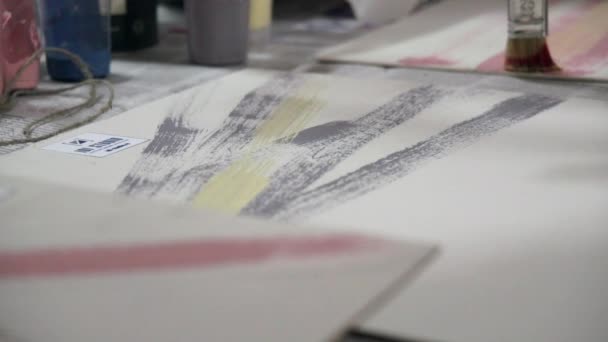 Руки художника фарбують пензлем і фарбою на папері . — стокове відео