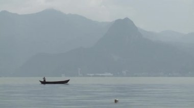 Adam bir gölde tekne yüksek dağlarda gezen.