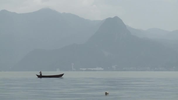 Mann schwimmt in einem Bootssee hoch in den Bergen. — Stockvideo