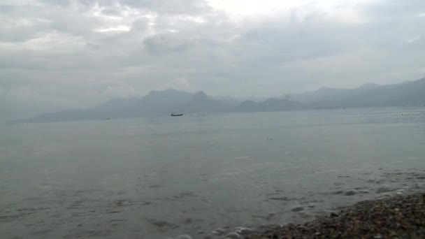 Στη λίμνη, στα βουνά ενάντια του ουρανού και ομίχλη πάνω από το νερό στην επαρχία Γιουνάν, Κίνα — Αρχείο Βίντεο