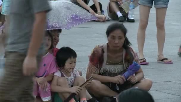 Family are sitting in rain on street city of Tiananmen Square. — Stock Video