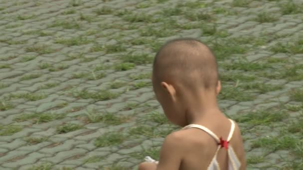 Niño caminando por las calles de la ciudad en el parque . — Vídeos de Stock