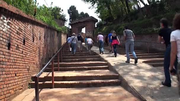 Tourists and locals go up stairs of old building on streets of Kathmandu Nepal. — Stock Video