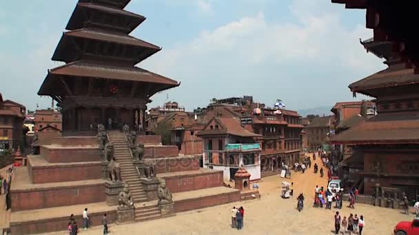 Туристів і місцевих жителів на площі біля храму. Архітектура будівель Катманду. — стокове відео
