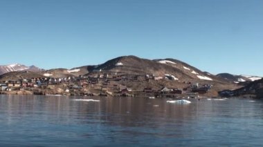 Küçük şehir dağlarda ve Grönland Kuzey Buz Denizi kıyısında.