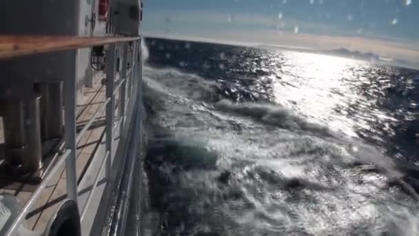 Montañas nevadas en el fondo de las olas. Cubierta de la nave . — Vídeo de stock