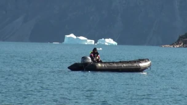 Tuffatore galleggiante in gommone sullo sfondo di iceberg, ghiaccio, nell'Oceano Artico . — Video Stock