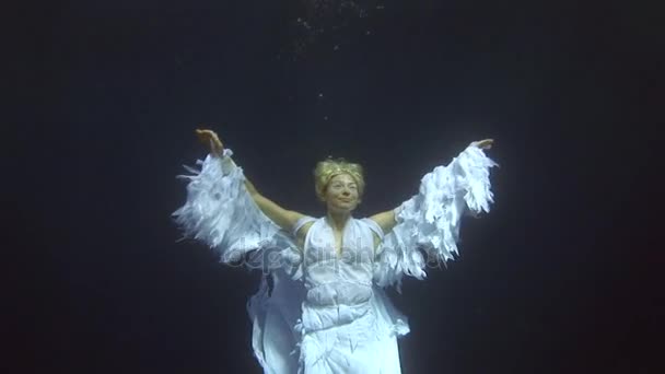 Podvodní model potápěč, v kostýmu anděla plave v čisté vodě v Rudém moři. — Stock video