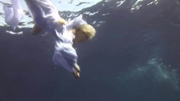 Underwater model free diver in costume angel swims in clean water in Red Sea. — Stock Video