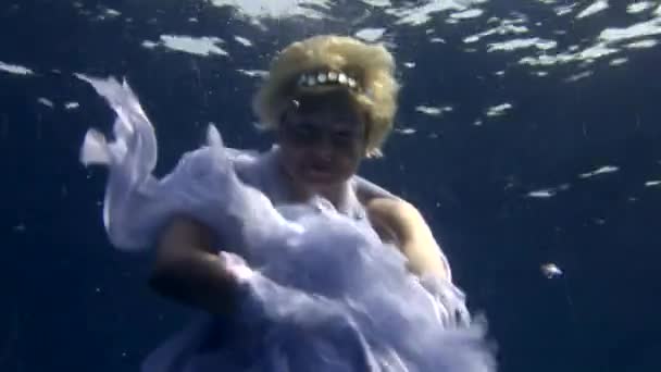 Underwater model free diver in costume angel swims in clean water in Red Sea. — Stock Video