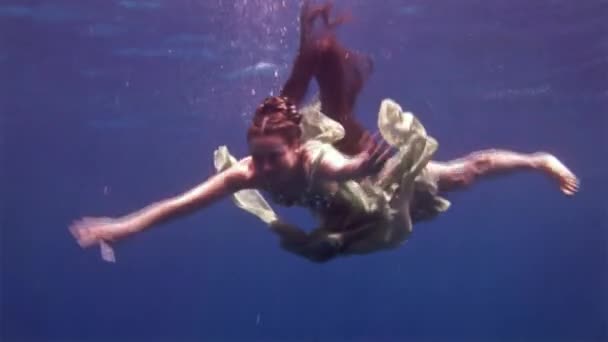 赤い海のサンゴの背景に妖精の衣装で水中モデル無料ダイバー. — ストック動画