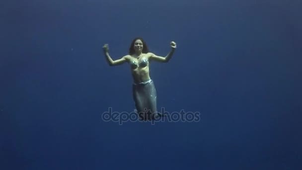 Молода дівчина модель підводні русалки костюм на синьому фоні позах в Червоному морі. — стокове відео