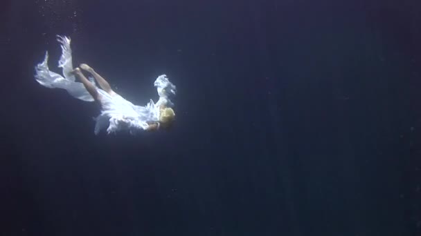 Jong meisje model onderwater witte engel kostuum op blauwe achtergrond in de rode zee. — Stockvideo