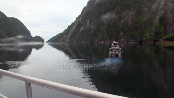 Boat sails on calm water of Pacific Ocean on background coast in Alaska. — Stock Video