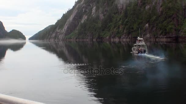 Boat sails on calm water of Pacific Ocean on background coast in Alaska. — Stock Video