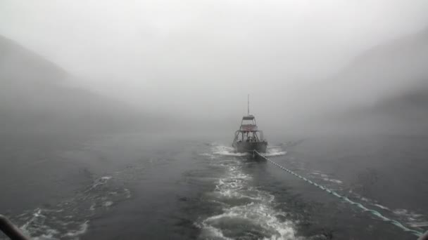 Barca trainare nella nebbia sull'acqua dell'Oceano Pacifico su montagne di sfondo Alaska . — Video Stock