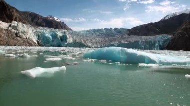 Buzlar su Alaska Pasifik Okyanusu'nda dağda arka plan üzerinde hareket.