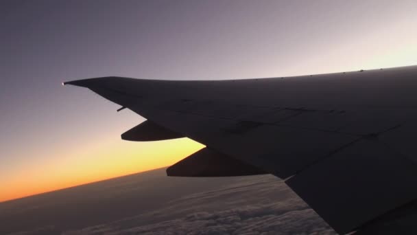 Skrzydła samolotu na tle zachodu słońca w niebo i chmury. — Wideo stockowe