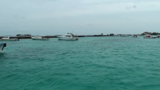 Jachten en boten op de achtergrond van het water en de kust op de Malediven. — Stockvideo