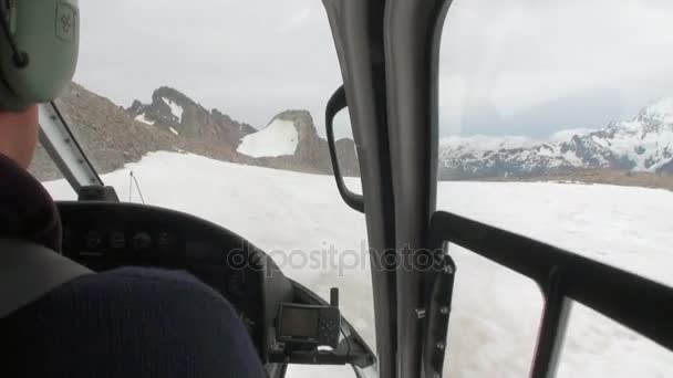Пилот вертолета летит на вертолетную площадку в снежных горах Новой Зеландии . — стоковое видео