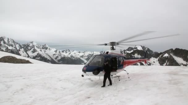 Piloto de helicóptero vuela a helipuerto en montañas nevadas en Nueva Zelanda . — Vídeos de Stock