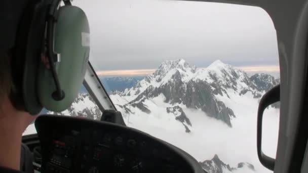 Helicopter pilot flies to helipad in snowy mountains in New Zealand. — Stock Video