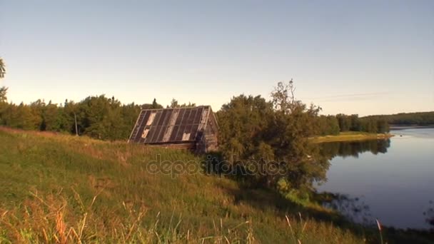 Заброшенный рыбацкий домик или охотничий домик на высоком берегу Белого моря . — стоковое видео