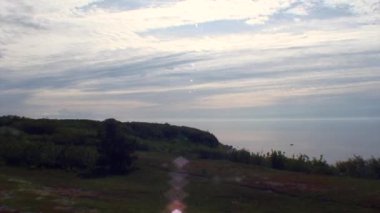 Yeşil beyaz deniz mavi gökyüzü ve bulutlar karşı kıyısında.