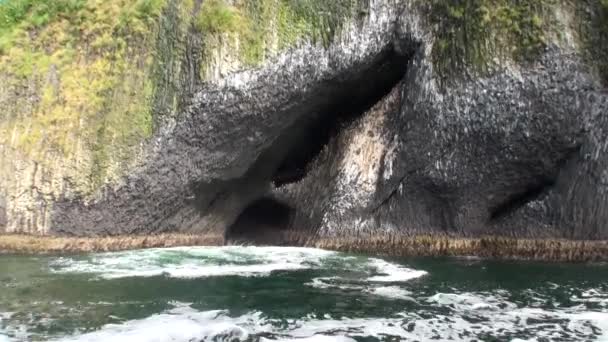 Unieke grot in de berg op de achtergrond van een glad wateroppervlak in Alaska. — Stockvideo