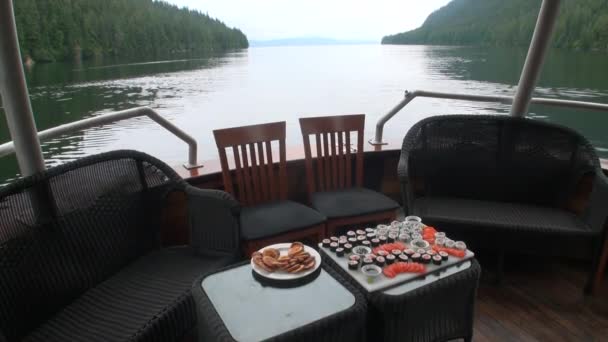 Sushi on ship on a background of wooden floor and wicker furniture. — Stock Video