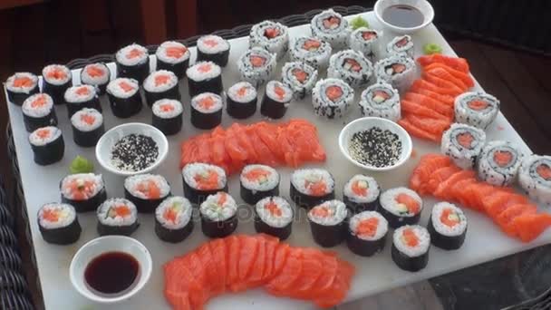 Sushi on a background of wooden floor and wicker furniture. — Stock Video