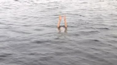 Kolların suyun altında Red Sea'deki/daki içine kadın dalgıç dalış.