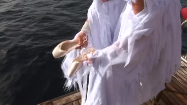 Model in white costume of angel clothes pointes on ship near water in Red Sea. — Stock Video