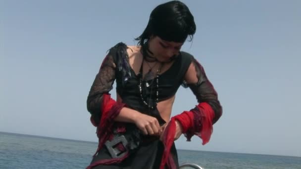 Model in white costume of pirate on ship near water in Red Sea. — Stock Video