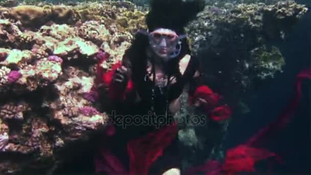 Junges Mädchen Modell Freitaucher unter Wasser in rotem Piratenkostüm im roten Meer. — Stockvideo