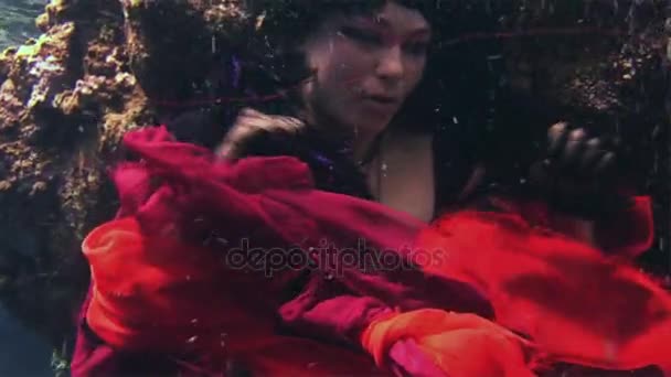 Young girl model free diver underwater in red costume of pirate in Red Sea. — Stock Video