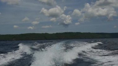 Endonezya'da deniz ufuk çerçevede bir motorlu tekne dalgalardan.