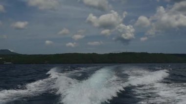 Endonezya'da deniz ufuk çerçevede bir motorlu tekne dalgalardan.